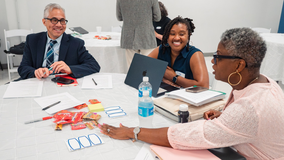 Three faculty of diverse backgrounds engage in a discussion