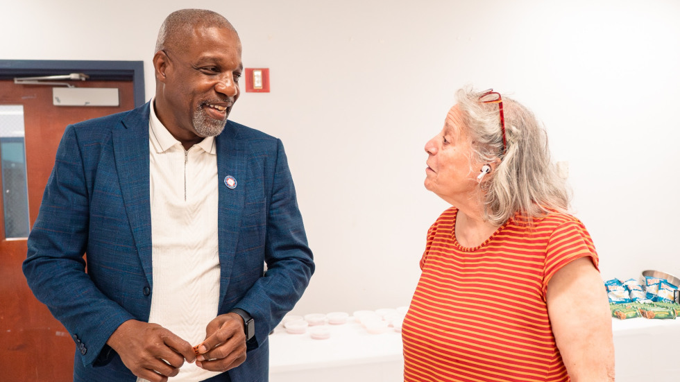 A man and an elderly woman are seen engaged in discussion