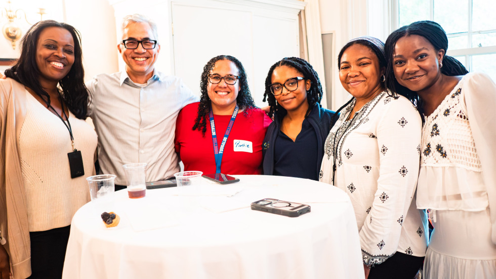 A male staff member poses with female collegues and students