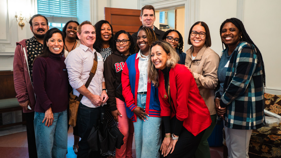 A group of people of diverse backgrounds pose for a photo. 